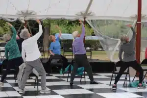 Group of people stretching outdoors during a class